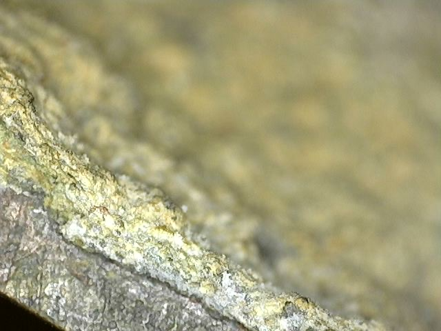 Mikroskopische Analyse der Patina auf der Brahma-Bronze Lot 162: Koexistenz von tiefrotem Cuprit und schwarzem Tenorit (Kupferoxide), verwachsen mit Resten von Feuervergoldung und mineralischen Sedimenten, 18. Jahrhundert, 1stbuddha Expertise.