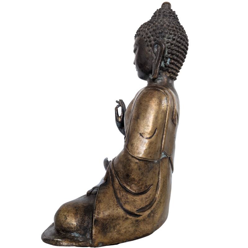 Detailansicht eines Bronze-Buddha-Kopfes mit Locken und historischer Lackmarkierung