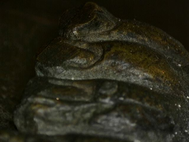 Mikroskopische Ansicht der Oxidationsschicht einer thailändischen Bronze-Figur. Mehrschichtige mineralische Korrosion und tiefsitzende Patina-Strukturen belegen das Alter und die Authentizität der 83 cm Rama-Statue, Lot 445, 1stbuddha.