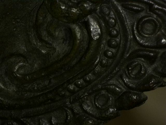 Mikroskopische Detailaufnahme eines Ornaments der thailändischen Rama Bronze-Statue. Die 80-fache Vergrößerung zeigt die feine handwerkliche Ziselierung des Gewandes und die natürliche mineralische Patina in den Vertiefungen, Lot 445, 1stbuddha.